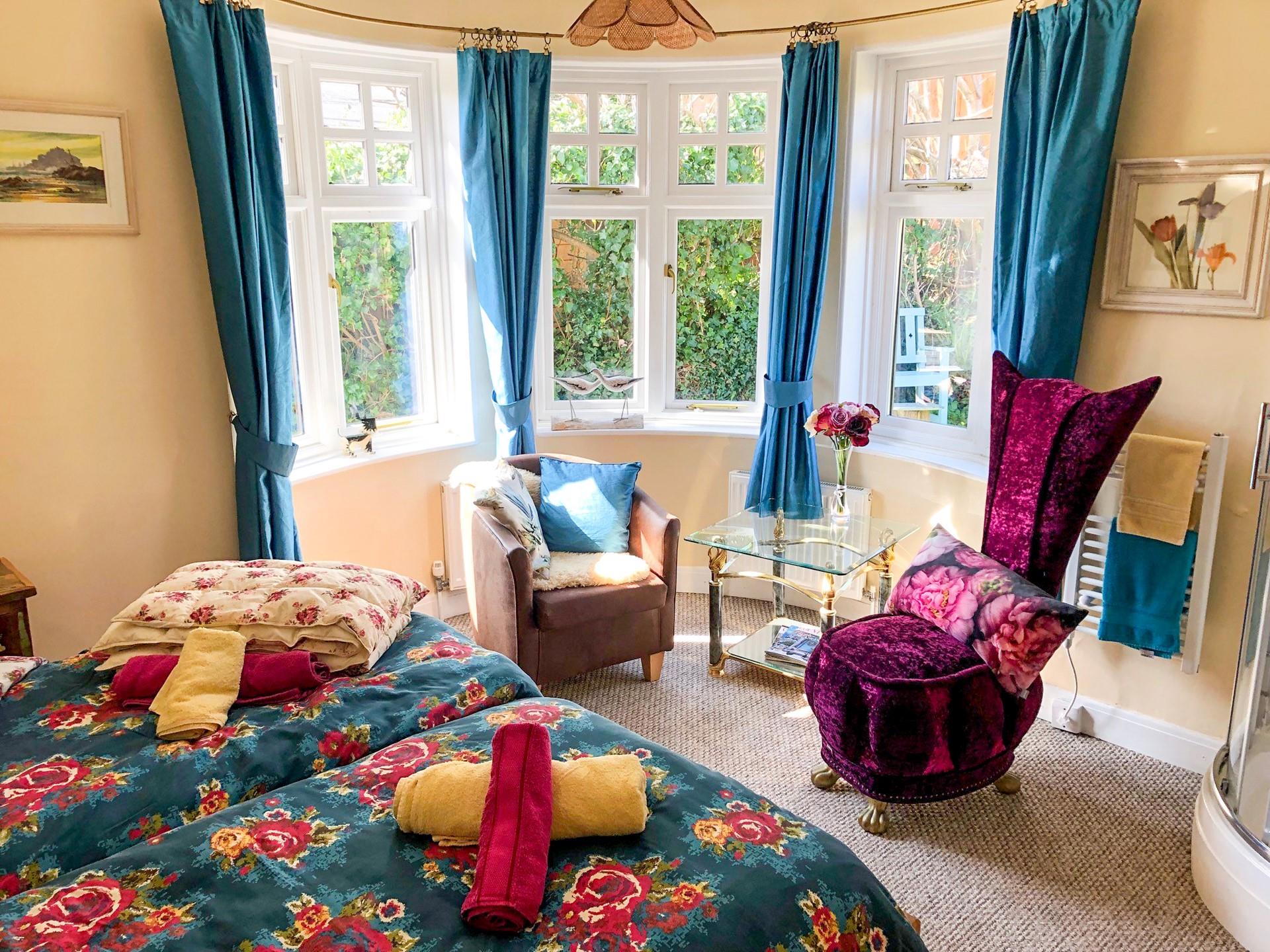 Bright, light and colourful, bedroom 1 benefits from three large windows and a corner shower. 