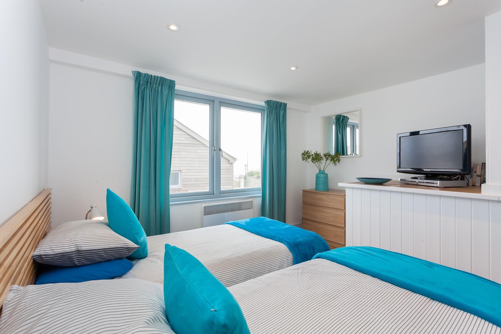 The twin bedroom continues the seaside theme with blue interiors.