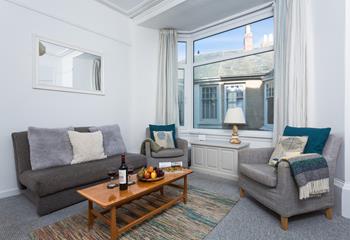 The large bay window brightens up the comfy sitting room and provides beautiful sea views.