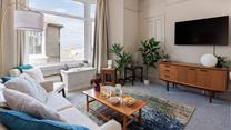 The large bay window brightens up the comfy sitting room and provides beautiful sea views.