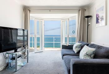 Large windows and patio doors offer breathtaking views across Carbis Bay beach. 