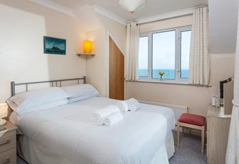 Crisp, white linen and sea views create a truly luxurious room.