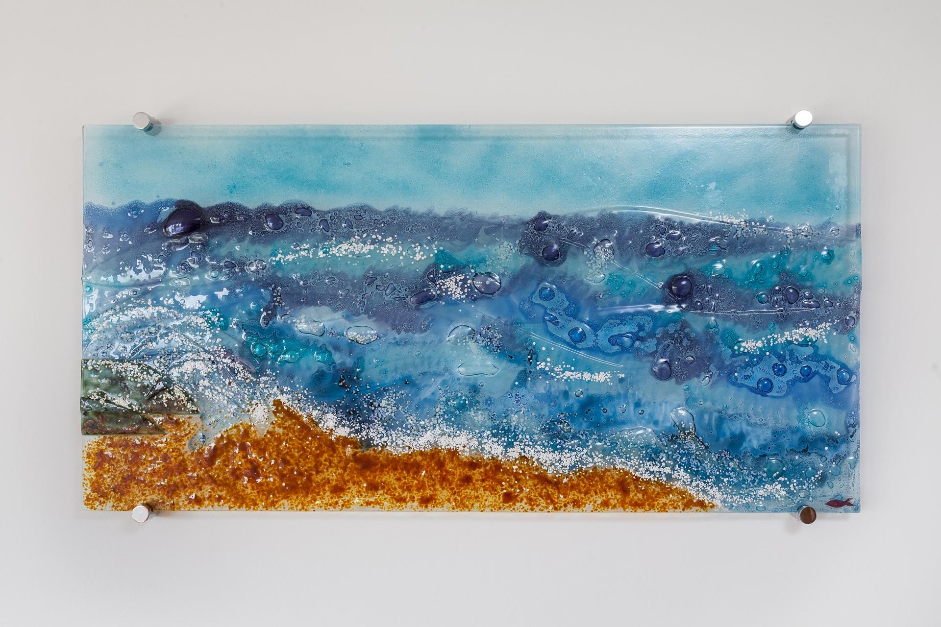 The fused glass wall art encapsulates the sea, sand and surf.