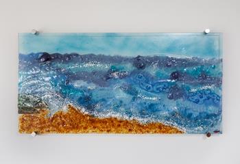 The fused glass wall art encapsulates the sea, sand and surf.