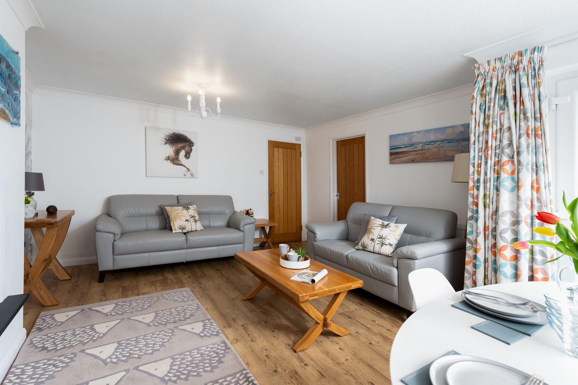 Beautifully light and spacious, the living area/dining room features large windows and a glass door, allowing natural light to fill the room. 