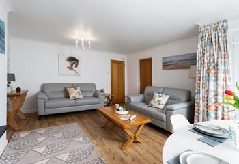 Beautifully light and spacious, the living area/dining room features large windows and a glass door, allowing natural light to fill the room. 