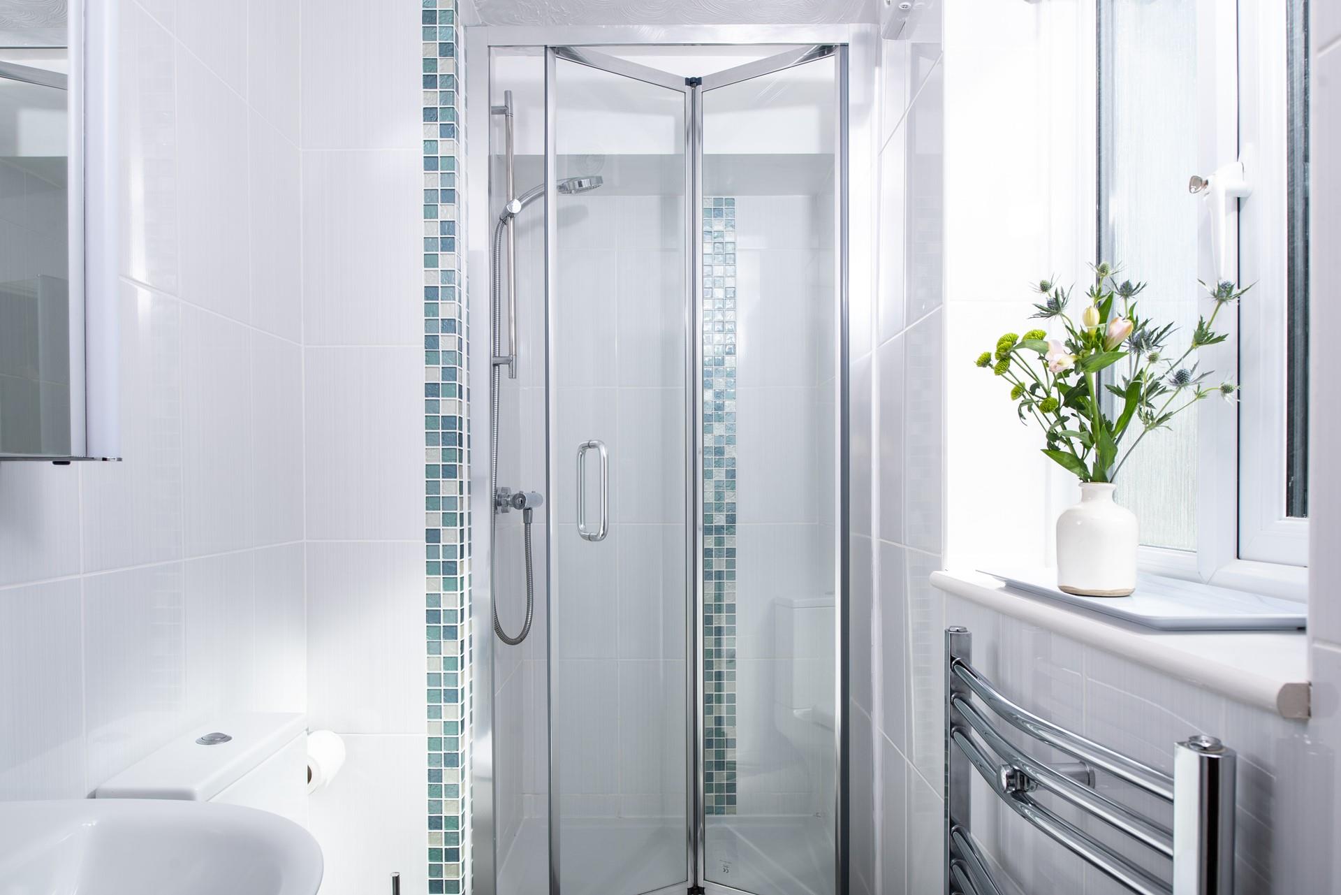 The en-suite shower room features a convenient heated towel rail. 