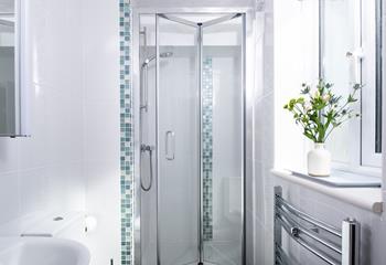 The en-suite shower room features a convenient heated towel rail. 