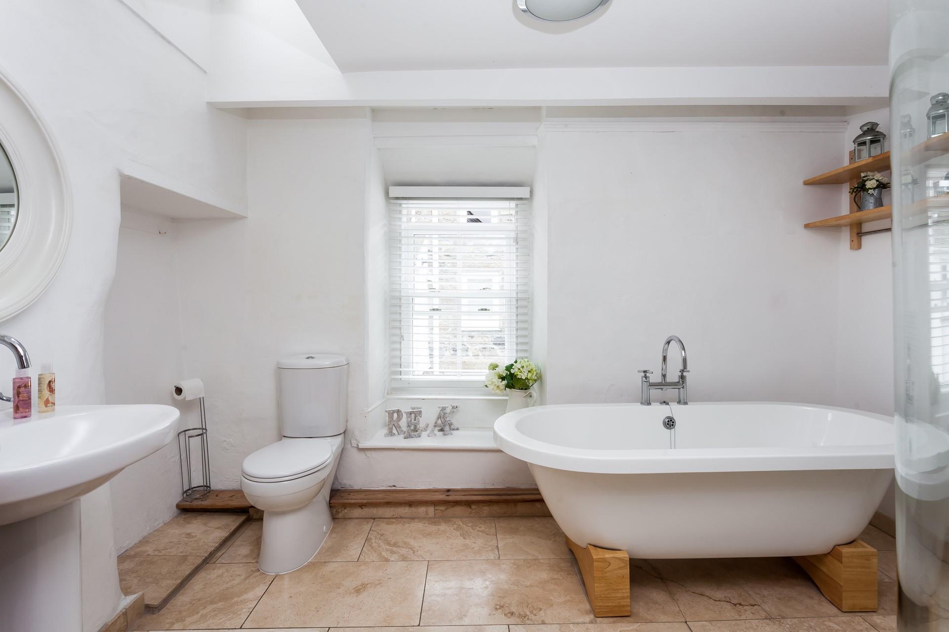 The family bathroom is spacious, with a luxurious free-standing bathtub.
