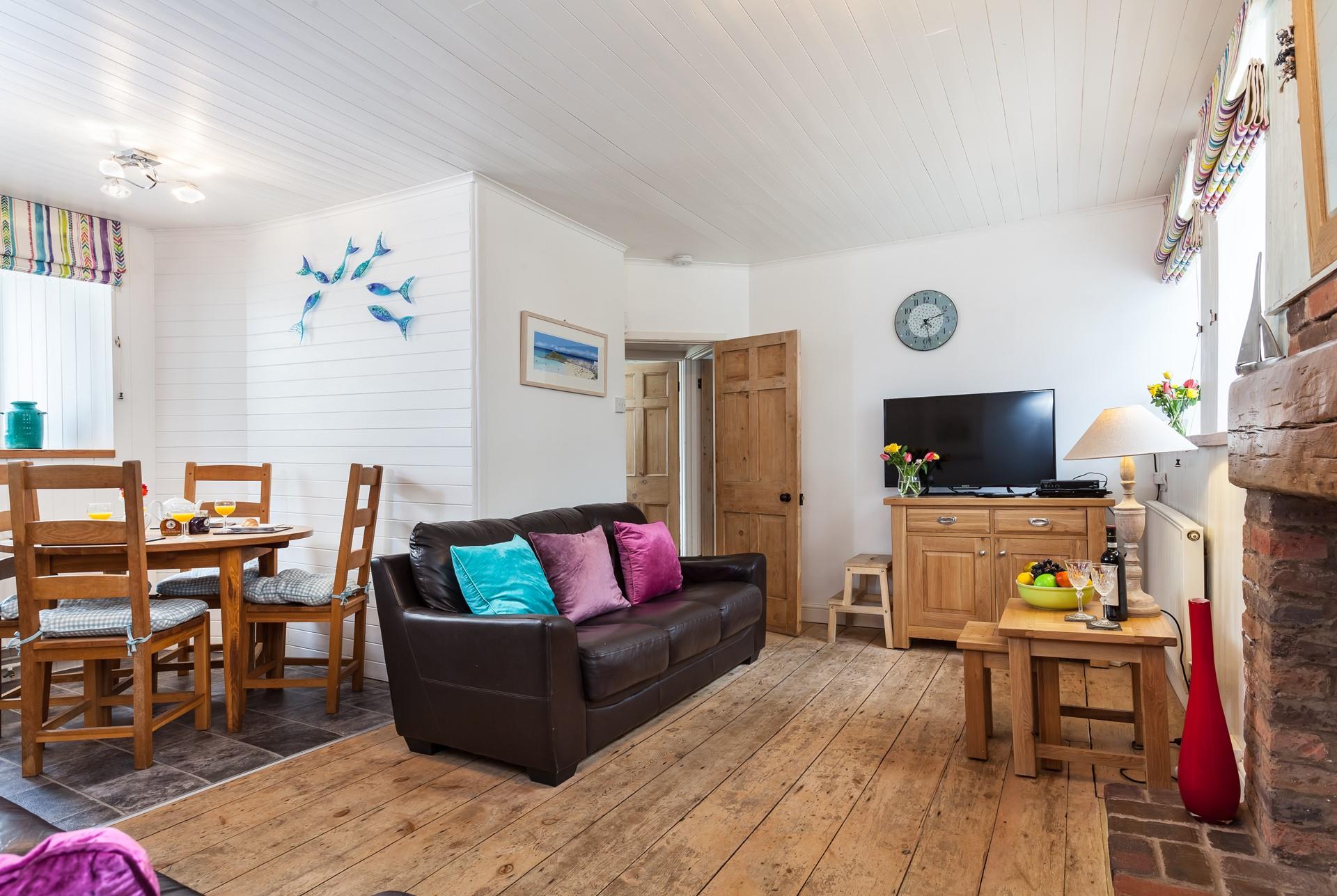 Cosy open plan living with original features, sink into the sofa after a busy day of exploring.