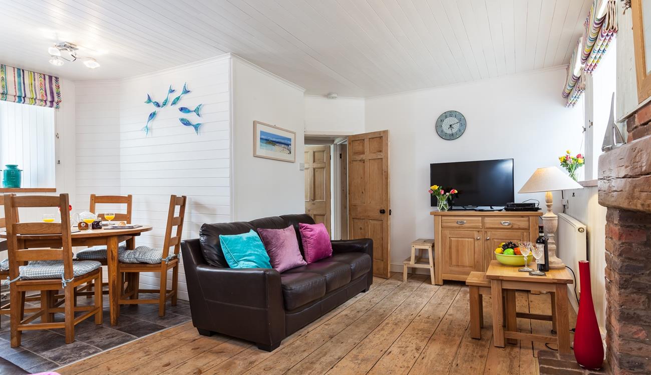 Cosy open plan living with original features, sink into the sofa after a busy day of exploring.