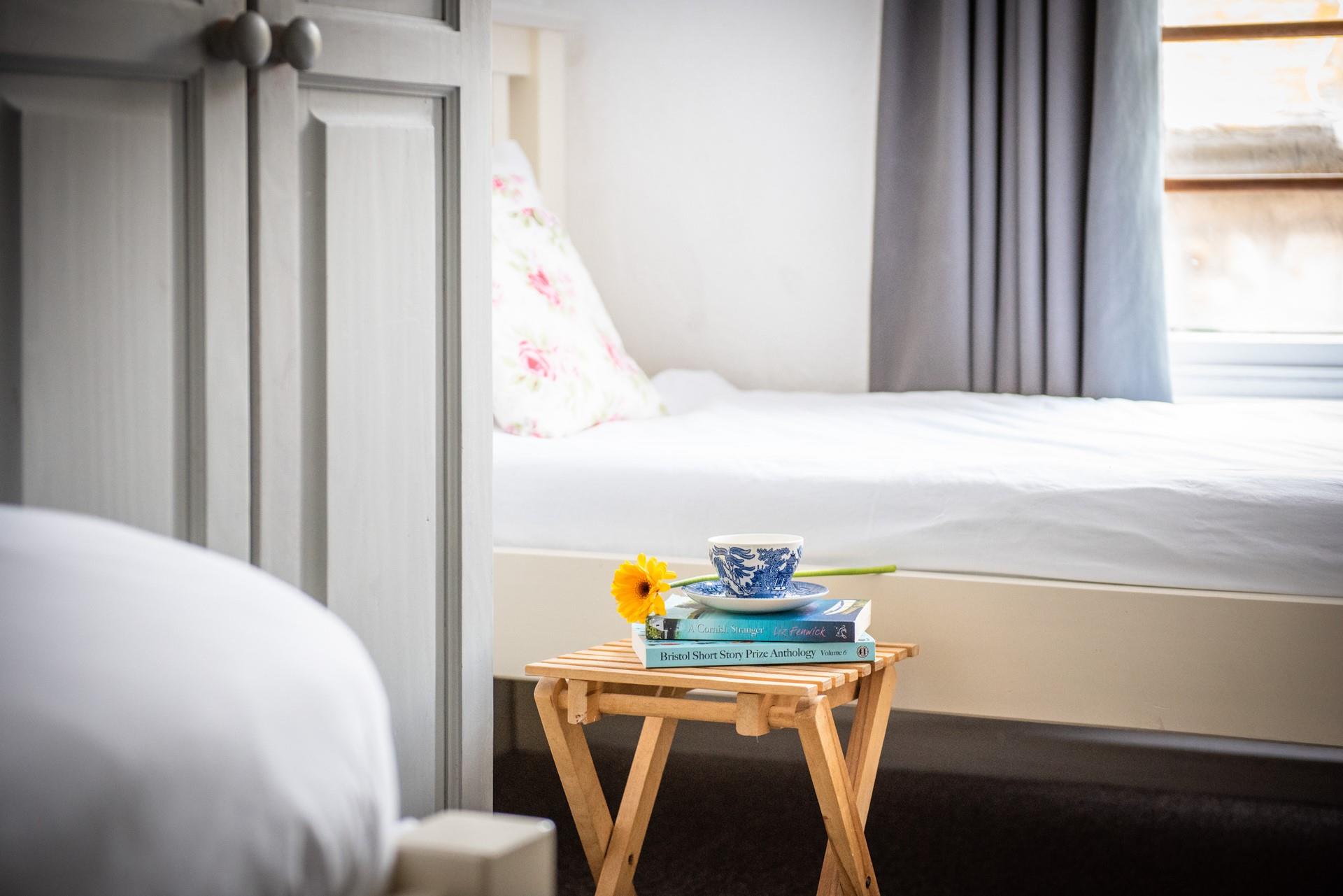 Bedroom 1 has a useful natural wood folding bedside table that is functional and maximises space.