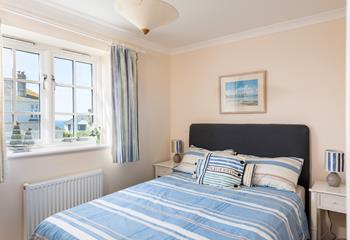 Bedroom 1 has a spacious double bed and is decorated with blue ocean decor.