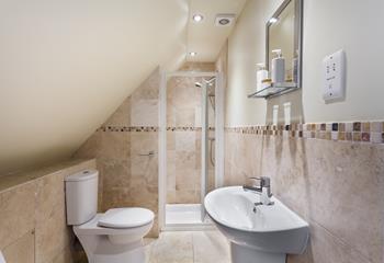 The en suite is decorated in soothing neutrals, offering a calming space to get ready or freshen up.