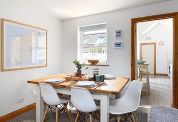 The sitting/dining room has bright artwork and cosy furnishings.