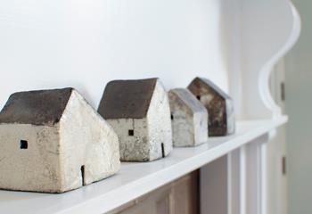 Raku pottery cottages adorn the living space mantlepiece, simplistic ceramics with a real earthy vibe.