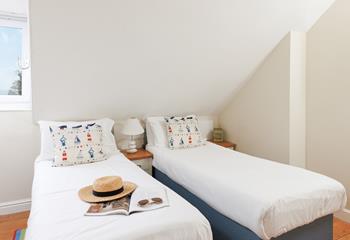 Pops of nautical decor and sea views create a lovely coastal bedroom.