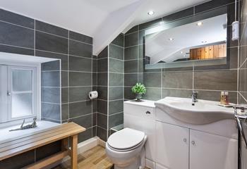 Newly refurbished, the family bathroom is spacious with plenty of storage space.
