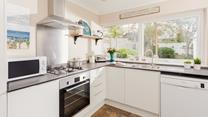 The modern and well-equipped kitchen provides the chef of the family a space to cook delicious meals.