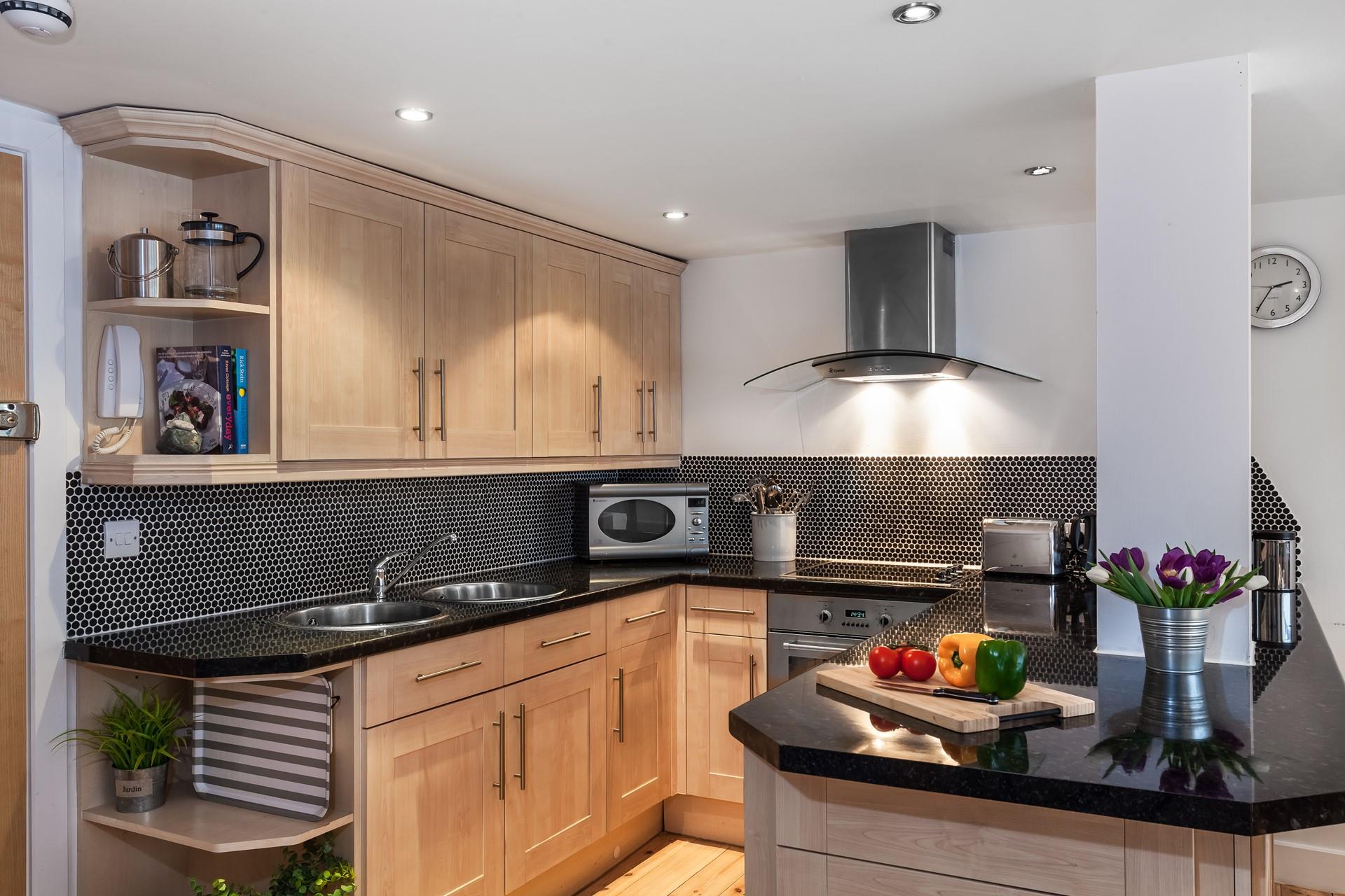 A stylish U-shape kitchen is perfect to keep the open plan flow going whilst being a clever use of space.
