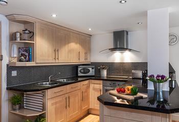 A stylish U-shape kitchen is perfect to keep the open plan flow going whilst being a clever use of space.