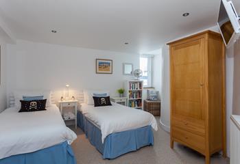 Bedroom 2 has twin beds and a bookshelf full of books, making it perfect for children or young adults.