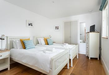 Bedroom 2 is decorated with a pop of colour with cosy cushions.