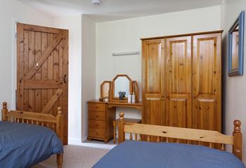 Bedroom 1 features twin beds and oak furniture, perfect for kids or adults.