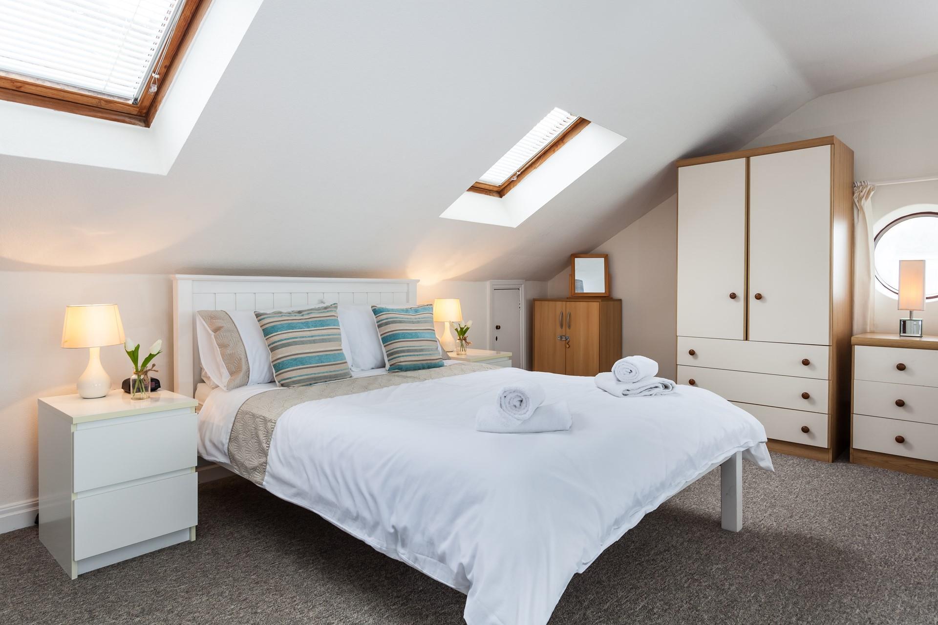 The spacious open plan main bedroom offers stunning sea views.