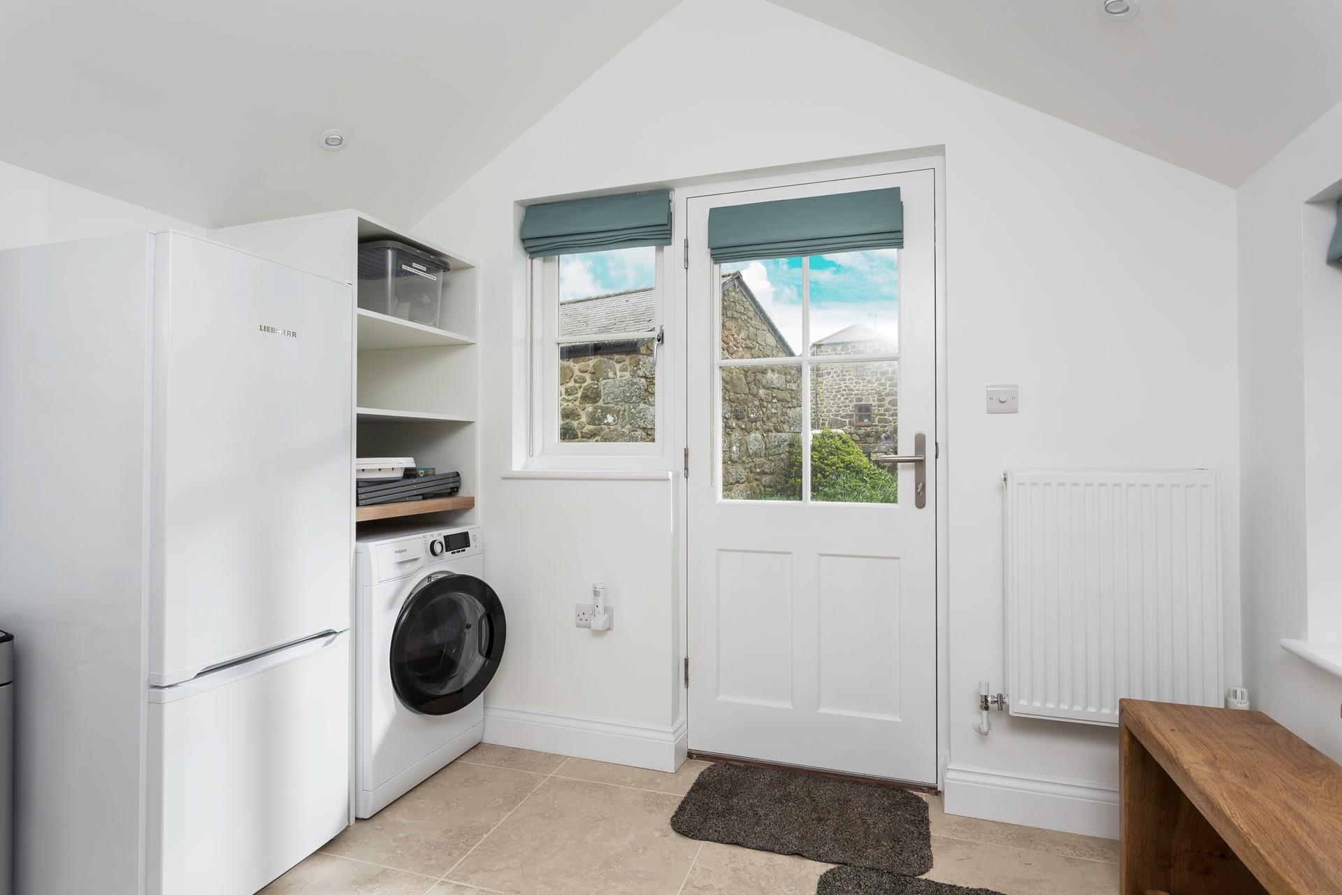 The utility has a washing machine and fridge.