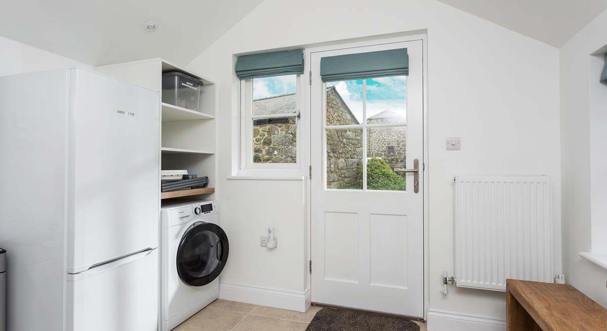 The utility has a washing machine and fridge.