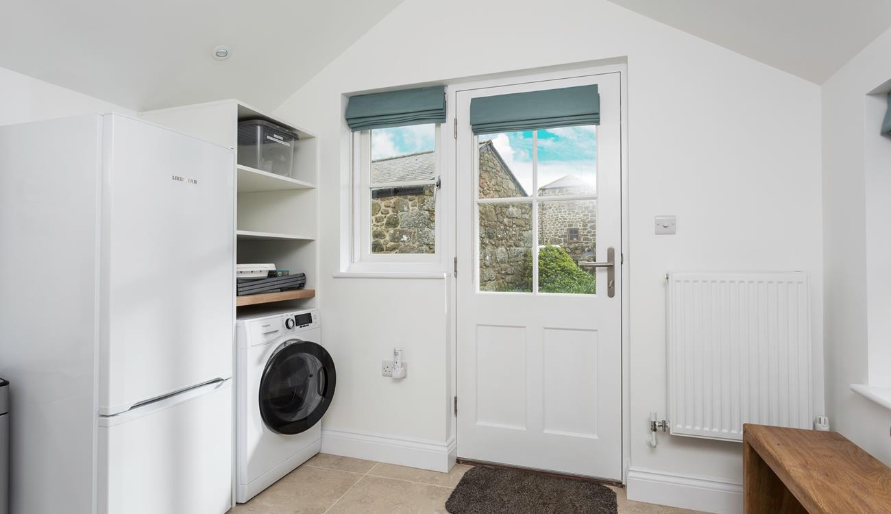 The utility has a washing machine and fridge.