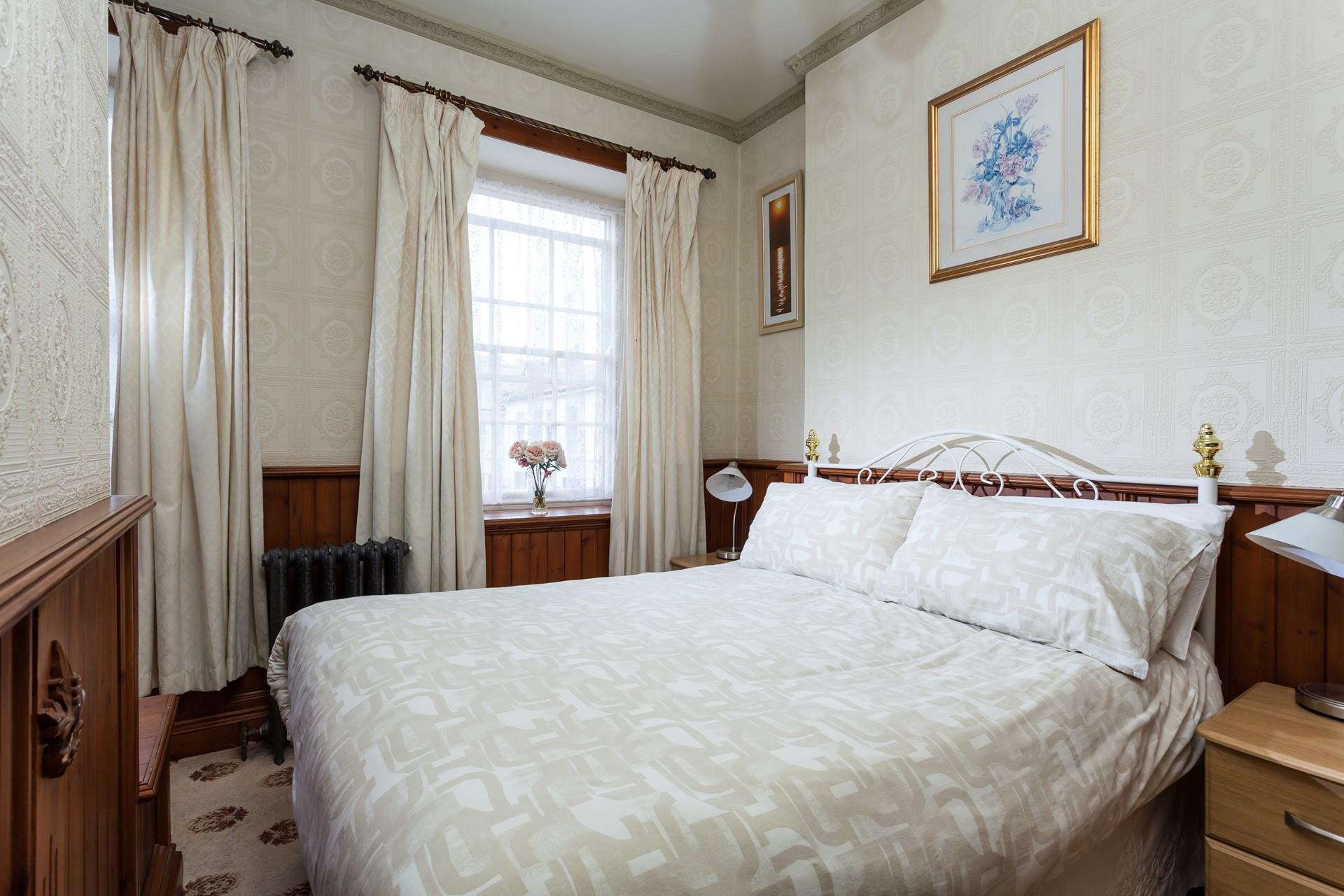 Bedroom 1 with a window overlooking the pretty square. 