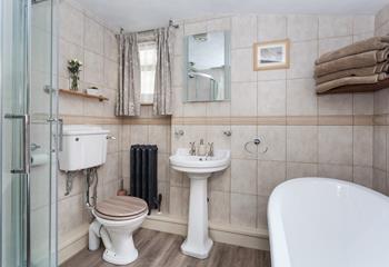 The bathroom contains a roll top bath and a separate contained shower. 