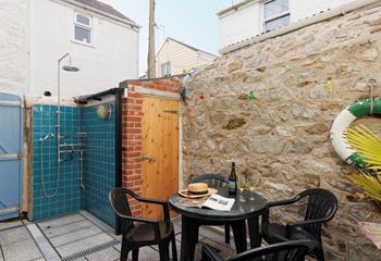 There is a decked outside area with a table and chairs.