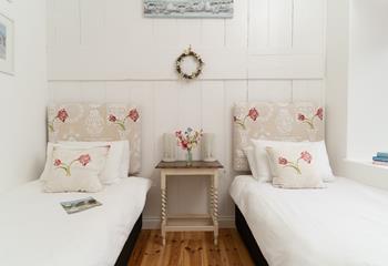 A delightful twin bedroom with rustic features and calming tones.