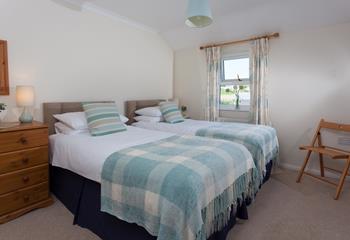 The second bedroom features twin beds, with sea views from the window. 