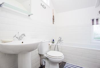 The en-suite for bedroom 2 has a bath and hand-held shower alongside a basin and WC.