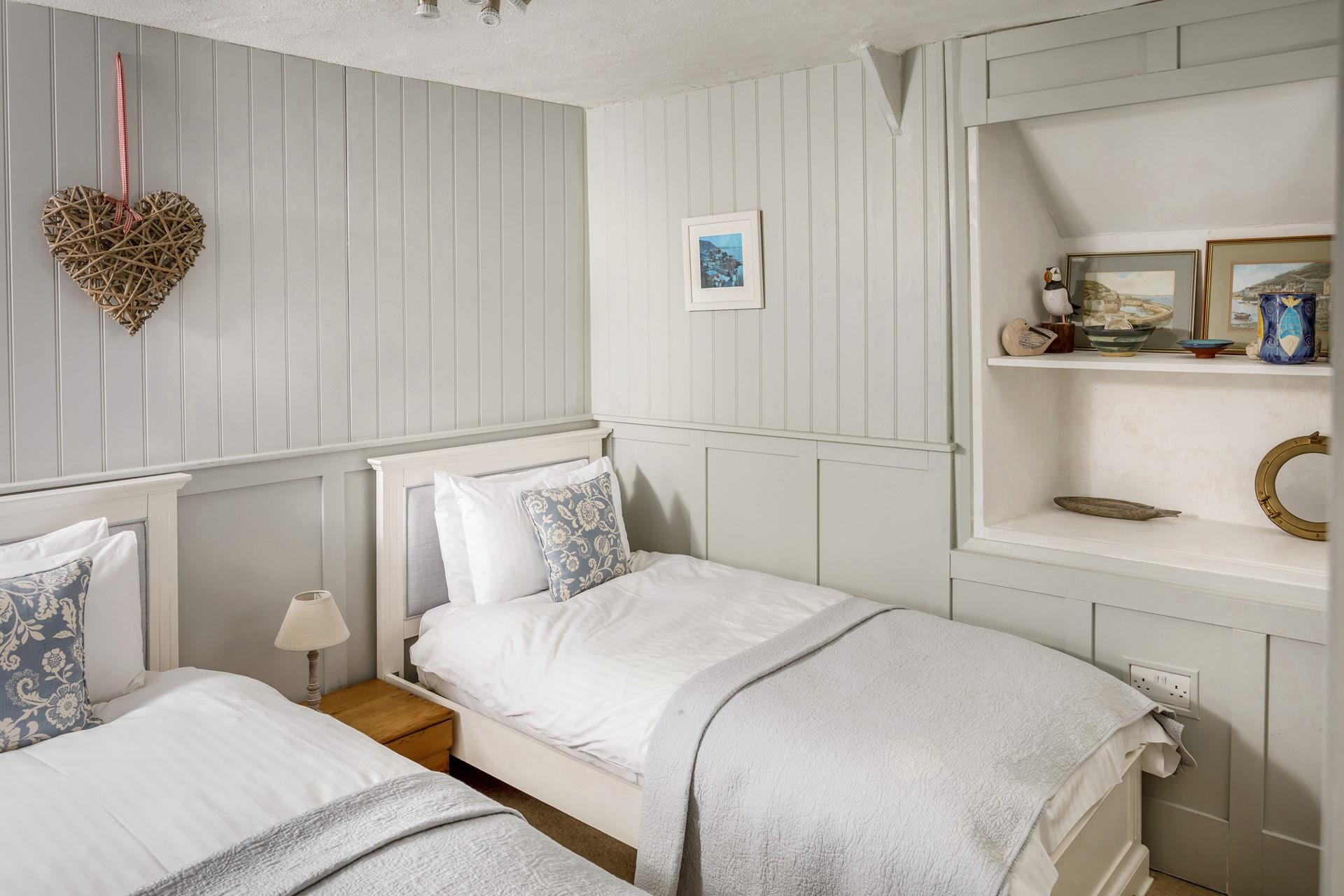 Bedroom 1 has two single beds with a grey and white interior - a lovely bedroom for children on a family break. 