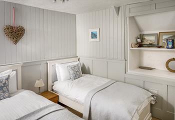 Bedroom 1 has two single beds with a grey and white interior - a lovely bedroom for children on a family break. 