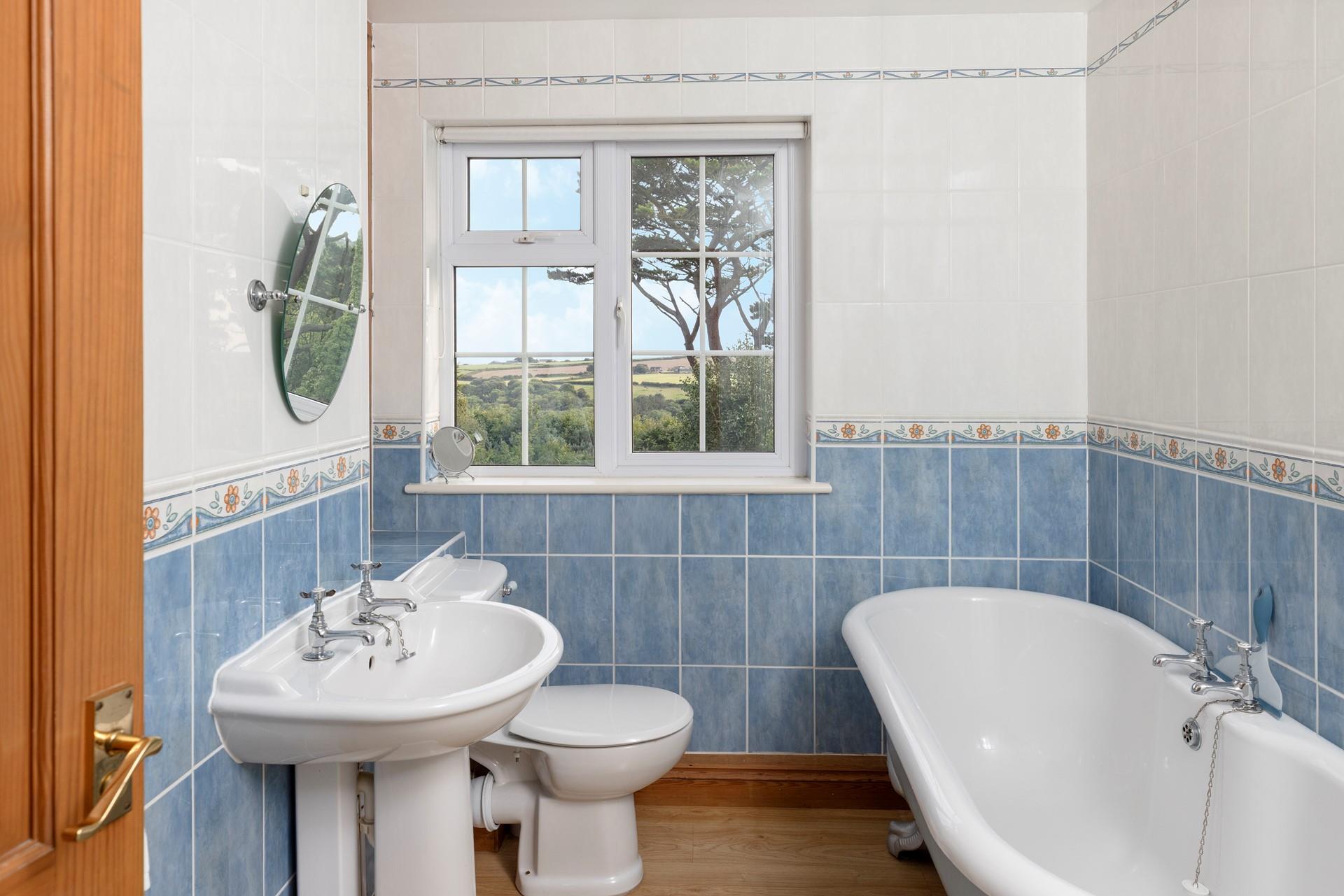 The bathroom has a luxurious roll-top bath and lovely country views.