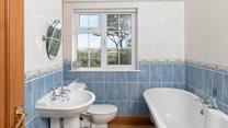 The bathroom has a luxurious roll-top bath and lovely country views.