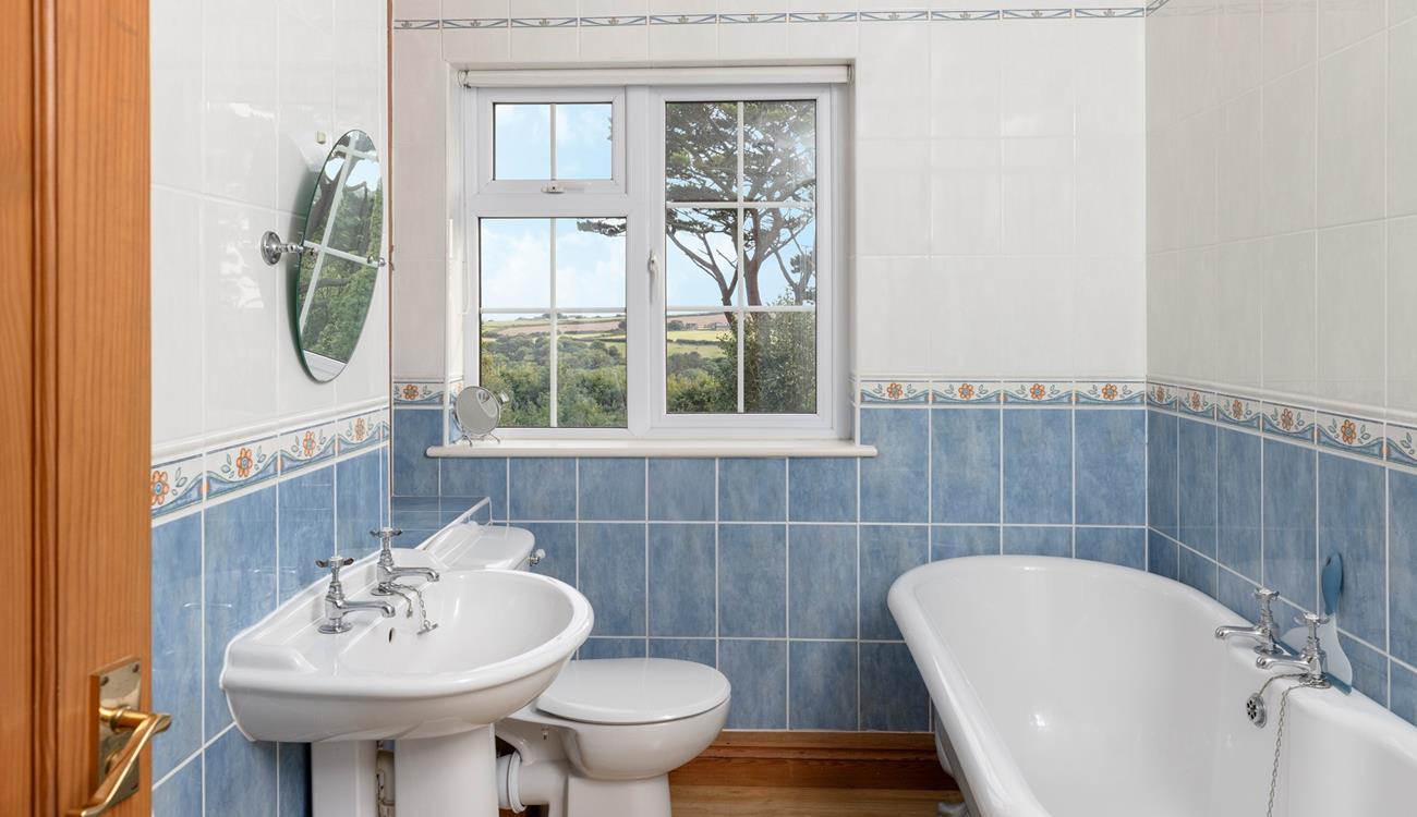 The bathroom has a luxurious roll-top bath and lovely country views.