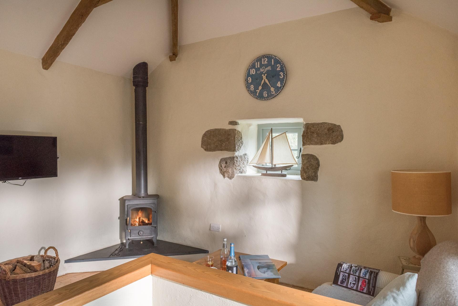 There is a sofa that seats two, facing the log burner. 