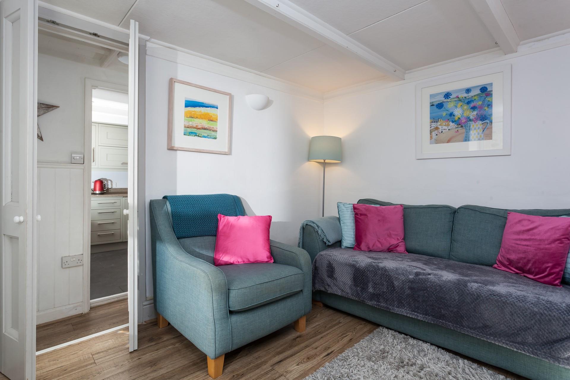 The sitting room features a cosy sofa and lovely rug, the perfect base to come back to after a long day.