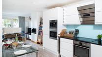 The kitchen is sleek and modern and even has a wine cooler!