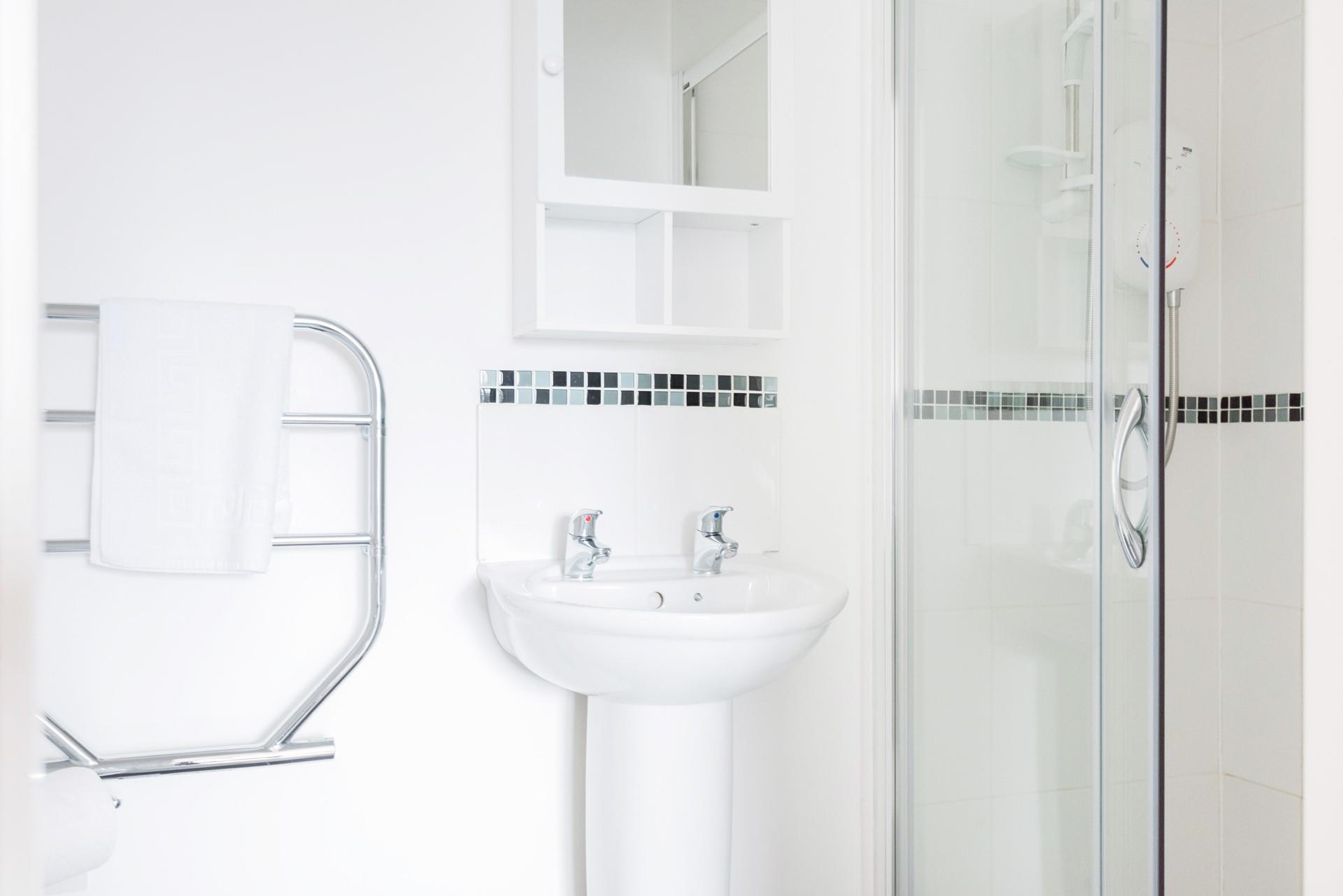 The bright white bathroom with monochromatic tiles is the perfect space to freshen up for the day ahead.