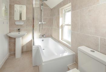 The bath is generously sized, ideal for enjoying an indulgent soak after a day on the beach.