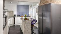 You'll find contemporary style blended with traditional cottage features, like the stone wall in the kitchen.