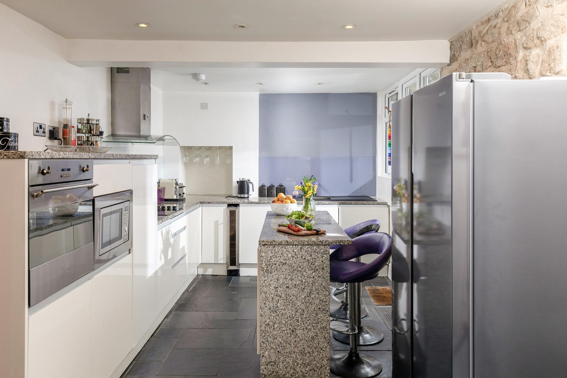 The sleek kitchen has modern amenities, including a larger American-style fridge freezer.